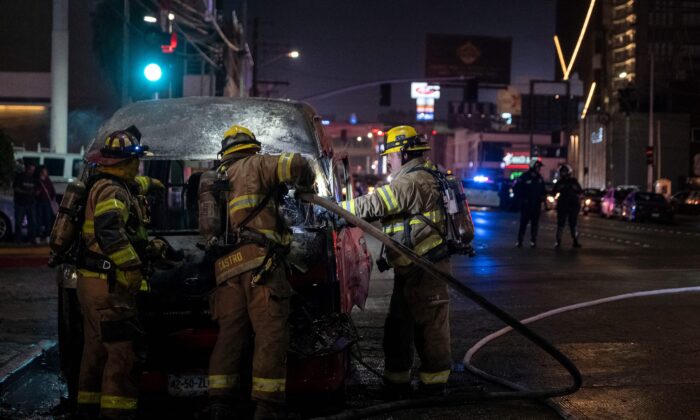 Пожарные тушат подожжённый неустановленными лицами автомобиль в Тихуане, штат Баха Калифорния, Мексика, 12 августа 2022 года. (Guillermo Arias/AFP via Getty Images)
 | Epoch Times Россия