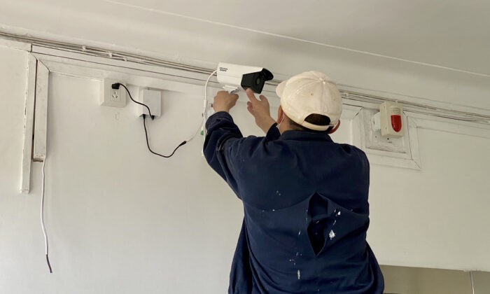 Рабочий настраивает камеру наблюдения у дома журналиста, помещённого на карантин после посещения им города Уханя. Пекин, Китай, 3 мая 2020 года. (Leo Ramirez/AFP via Getty Images) | Epoch Times Россия