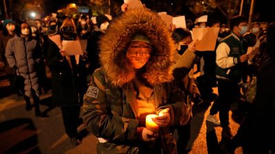 Протестующие держат чистые листы бумаги и скандируют лозунги во время марша протеста против жёстких антивирусных мер в Пекине 27 ноября 2022 года. (Ng HanGuan/AP Photo)